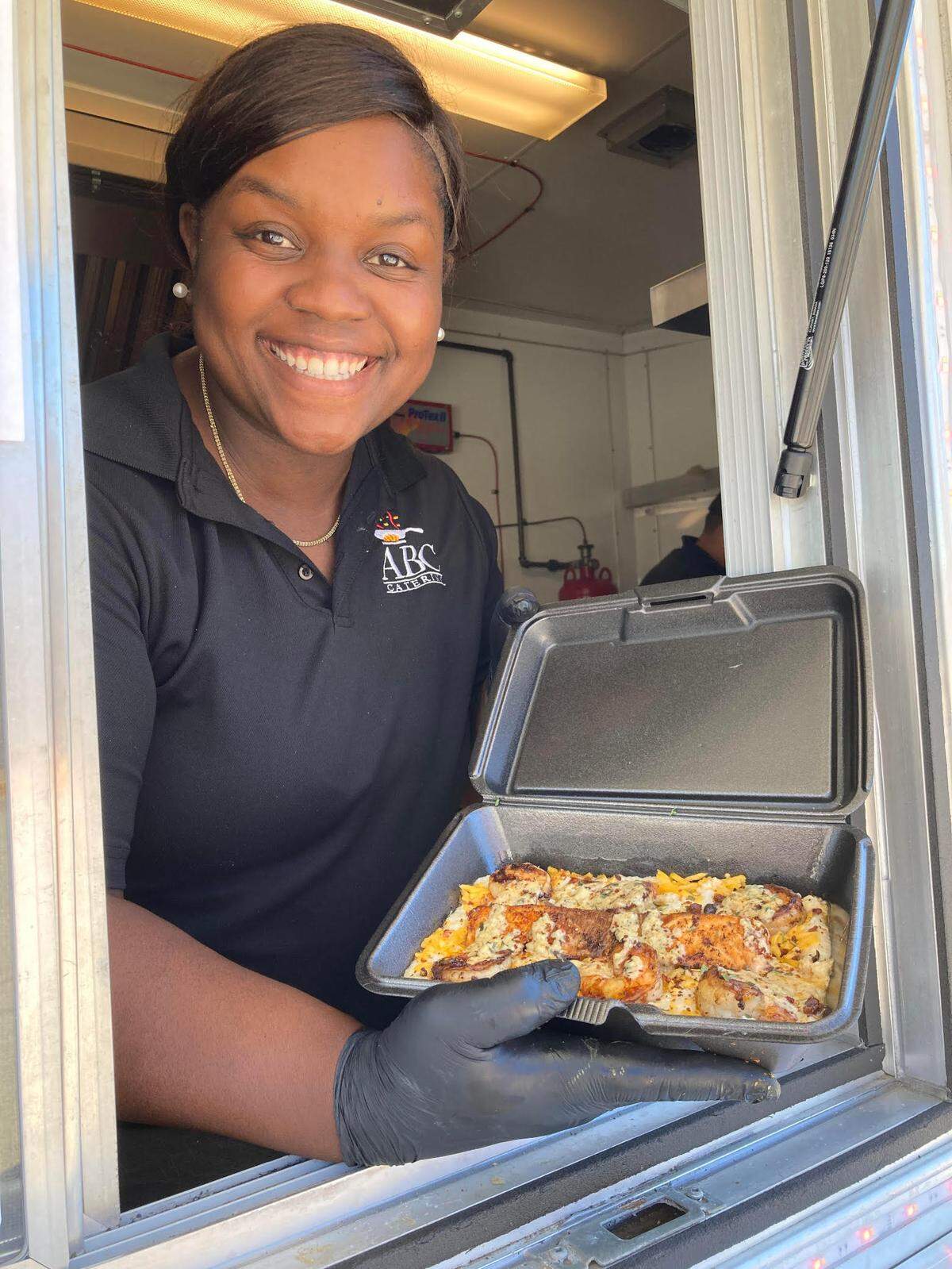 Allegra Lowe, owner of ABC Catering LLC, serves up salmon, shrimp and grits from her food truck in this 2022 Telegraph file photo.
