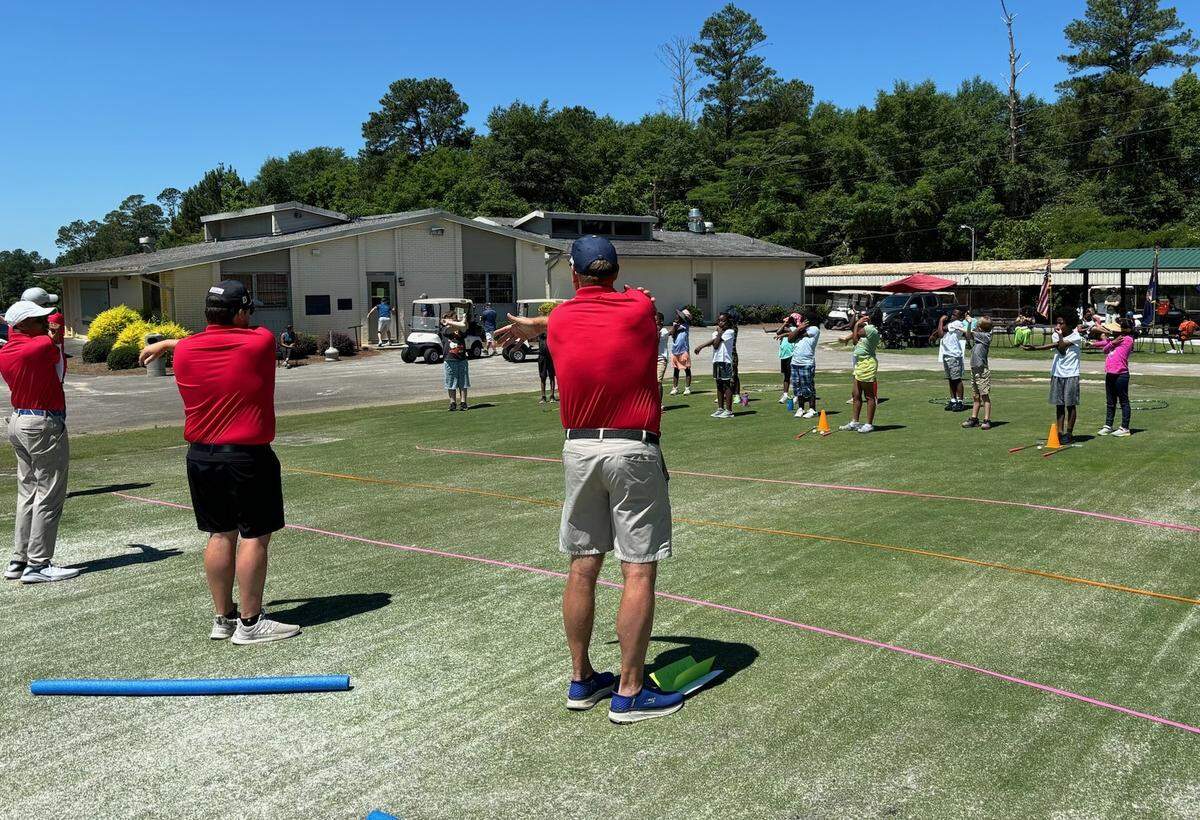 A First Tee - Middle Georgia youth class warms up with coaches before golf lessons.