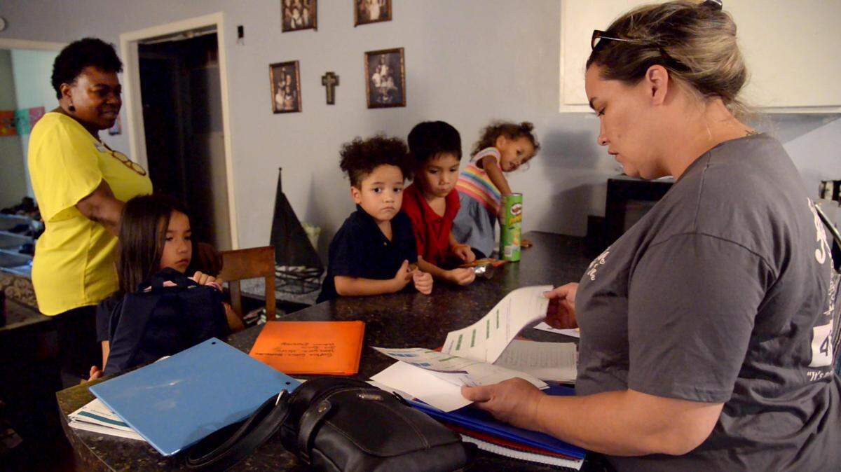 JENNA EASON/THE TELEGRAPH Macon, GA, 08/21/2019: Deborah Ferguson, right, goes through her children’s school folders as Marla Howard, a parent educator with the United Way of Central Georgia, looks on with Fergusons children, Sophia, Maurice, Joseph and Mirakle, left to right. Ferguson is enrolled with her daughter Mirakle in the Parents as Teachers program, which provides parents with information and resources they need. Howard is Ferguson’s parent educator. Parents can enroll their children between the ages 0 and 3 to the program, and their parent educators stay with them until the age of 5.