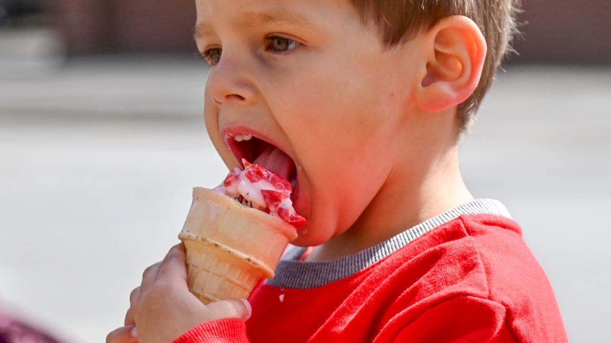 Thomas Robinson, 3, of Macon enjoys a cone of free cherry cordial ice cream at Third Street Park Tuesday. Guests can enjoy free ice cream, Coke and Krispy Kreme donuts daily from 11:30 a.m. - 1:00 p.m. through Friday.