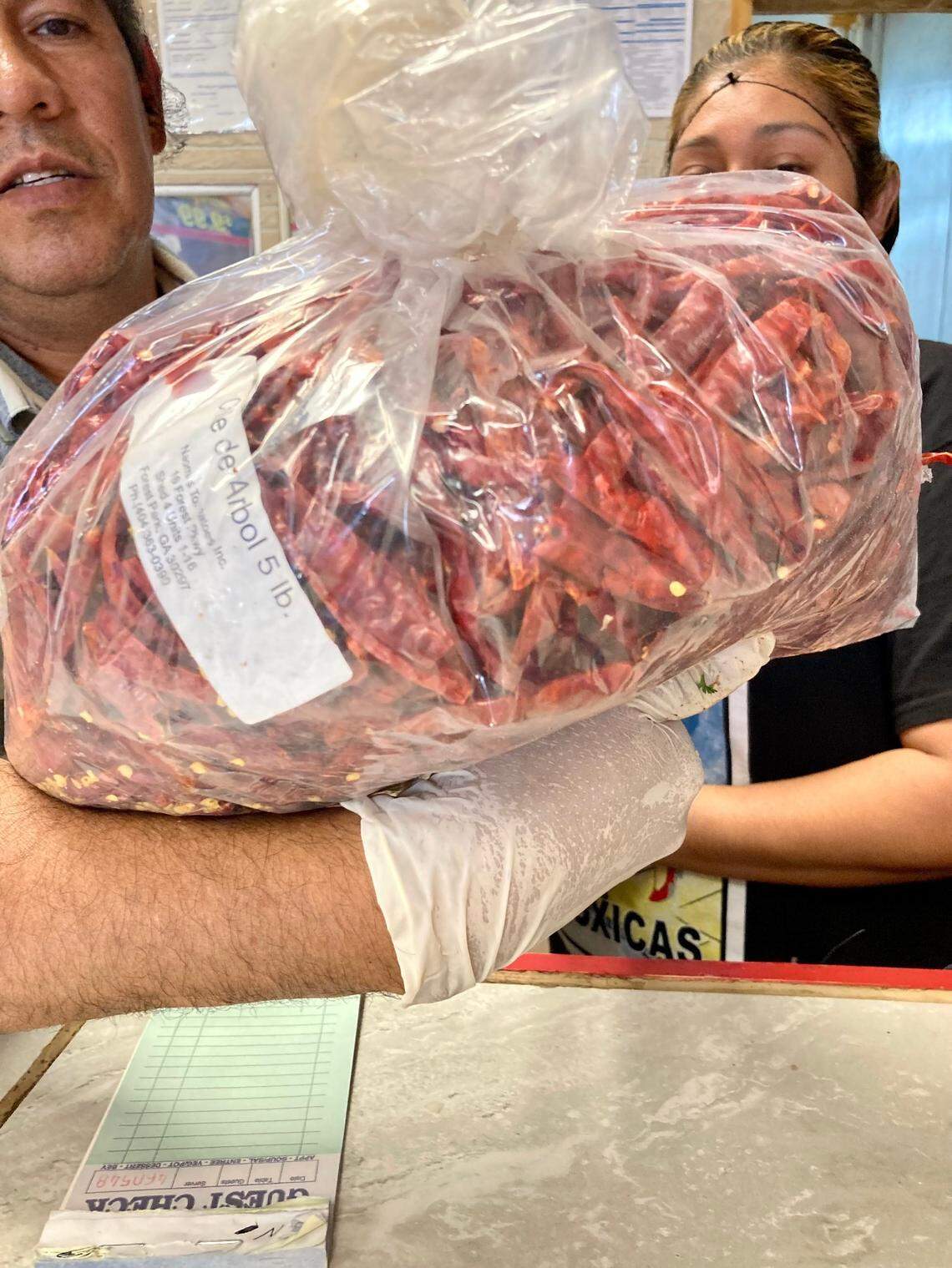 Samuel “Sammy” Naranjo holds up a bag of dried red chili peppers used to make a hot sauce, one of two salsa choices, made fresh at the restaurant he and his wife, Jenny Ramirez, own and operate in Warner Robins. Taqueria Don Sammy is located at 1431 Watson Blvd.