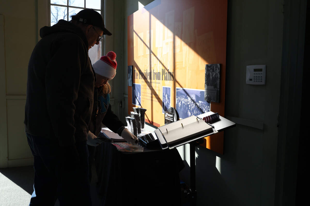 Visitors look at information on former president Jimmy Carter inside of his old campaign headquarters, which has been converted into a museum, on the day of former president Carter’s funeral in his hometown of Plains on Thursday, Jan. 9, 2025, in Plains, Georgia. A funeral service for Carter was held in Washington D.C. on Thursday morning with an additional funeral service later in the afternoon in Plains, where he will then be buried next to his wife Rosalynn Carter on his family’s peanut farm.