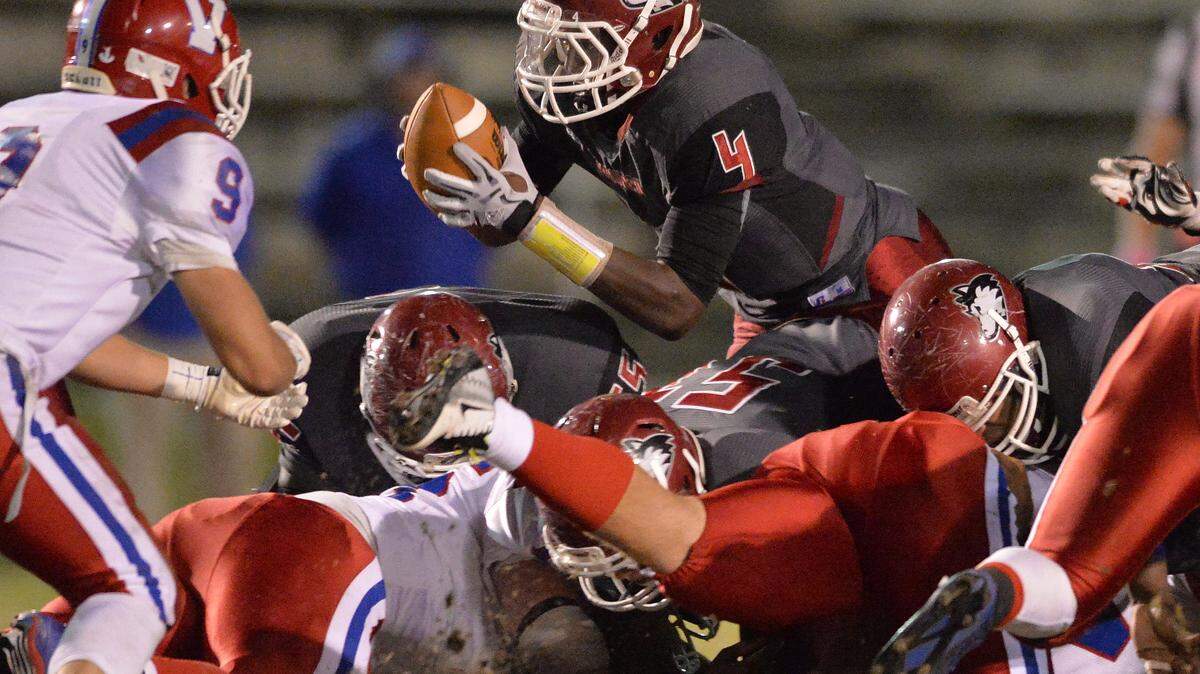 Howard quarterback Courvoisier King dives over the pile for Howard first down in their match-up against Veterans High Friday night.