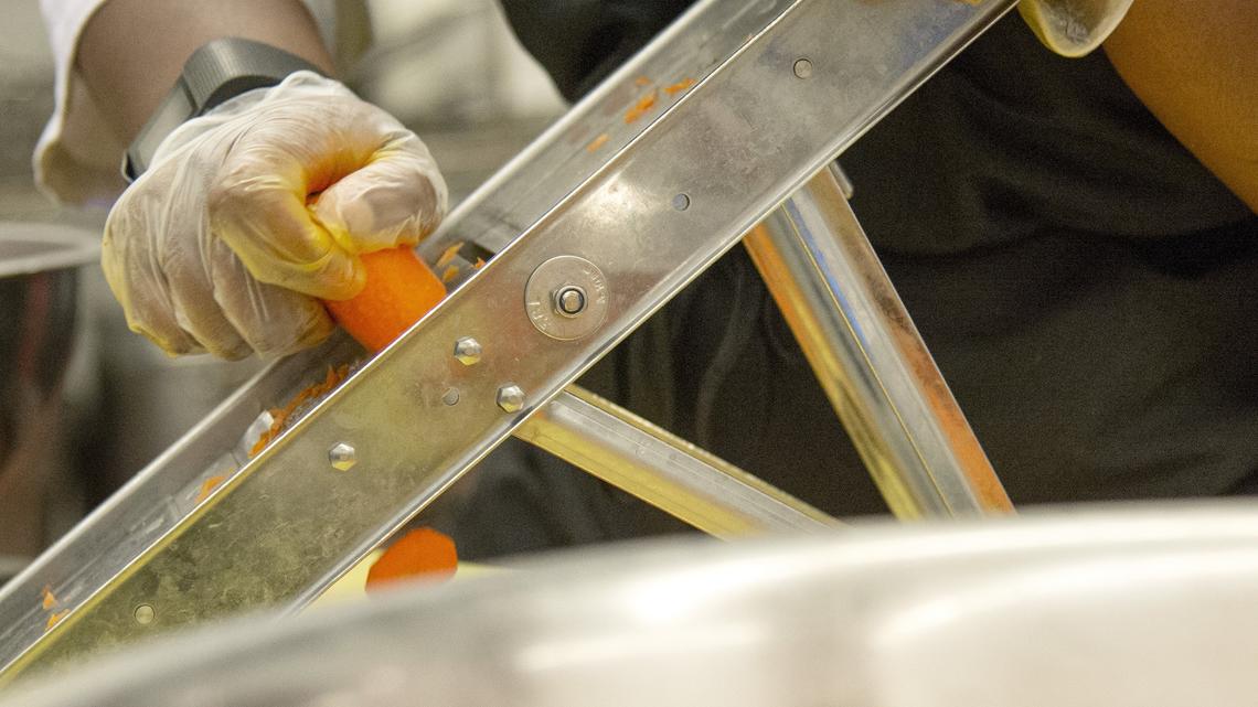 Carrots are sliced in preparation for lunch in the kitchen at Stratford Academy. Data shows Macon is seeing a high number of students experiencing homelessness, relying on school for shelter and food.