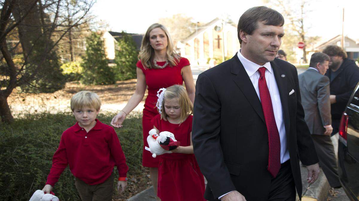 Georgia head coach Kirby Smart is followed by his wife Mary Beth and 7-year-old twins Westin and Julia to a waiting car after his introductory news conference Monday in Athens.