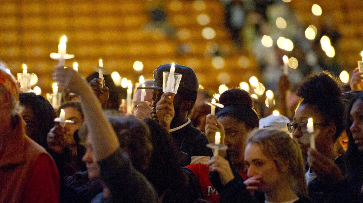 Students lift their candles as they sing the final verse of "Amazing Grace" at a vigil and remember Mercer basketball player Jabri Bryan Wednesday night in Hawkins Arena. Bryan, 23, was shot to death at the Flash Foods located at the corner of College and Forsyth streets on Tuesday afternoon.