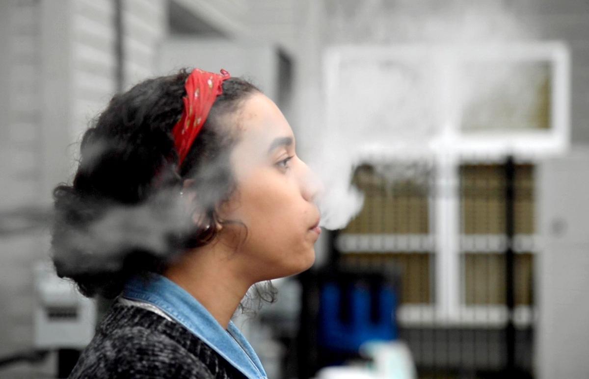 Noemi Griffin uses a Juul electronic cigarette while on a quick break at work Wednesday.