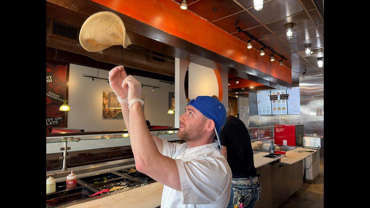 Jeremie St. Pierre, owner of the new Aria Pizza in Warner Robins, flips housemade pizza dough for the making of a pizza.