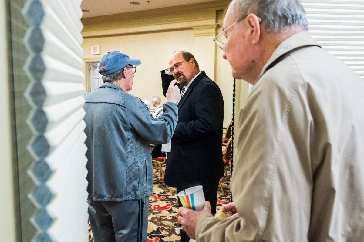 Tom Rockenbach, center, executive director of the Carlyle Place, Navicent Health, senior living facility in Macon talks with a resident before beginning the weekly community meeting he runs for residents.