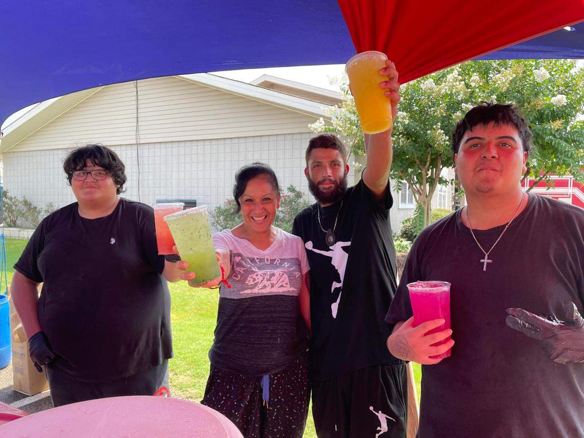 Jesus Villalon, Aguas Frescas Los Cholos owner, third from left, with Diana Ortiz, and her two sons, Ethan, 15, far left, and Juan, 18, far right, at the stand at Dunbar and Sandy Run roads in Warner Robins.