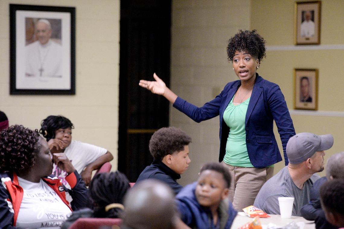 Sheknita Davis, executive director of In His Image Agency, answers questions from Crystal Lake Apartment residents Tuesday night during a town hall meeting for residents at Holy Spirit Catholic Church.