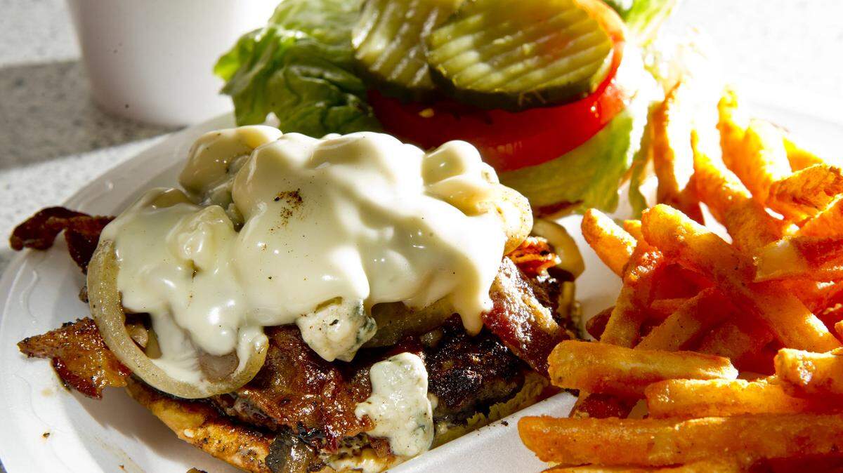 WOODY MARSHALL/THE TELEGRAPHThe Dickey Betts burger at Biscuits, Burgers & More is a blackened quarter-pound burger topped with mushrooms and onions, bacon, blue cheese crumbles and a slice of Swiss cheese.