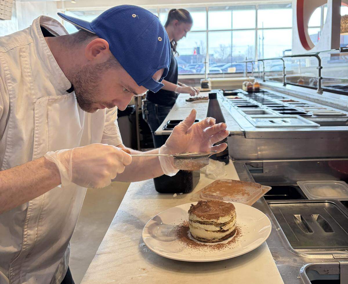 Jeremie St. Pierre, owner of the new Aria Pizza in Warner Robins, adds the final touch to his handcrafted tiramisu. 