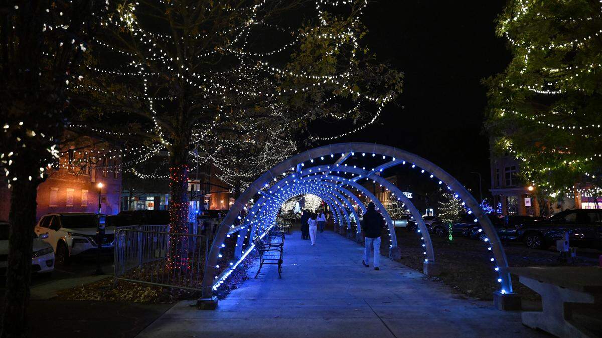 Visitors walk through the tunnel at the Macon Christmas Lights Extravaganza on Tuesday, Dec. 2, 2025, in downtown Macon, Georgia. The nightly light shows will occur throughout December.