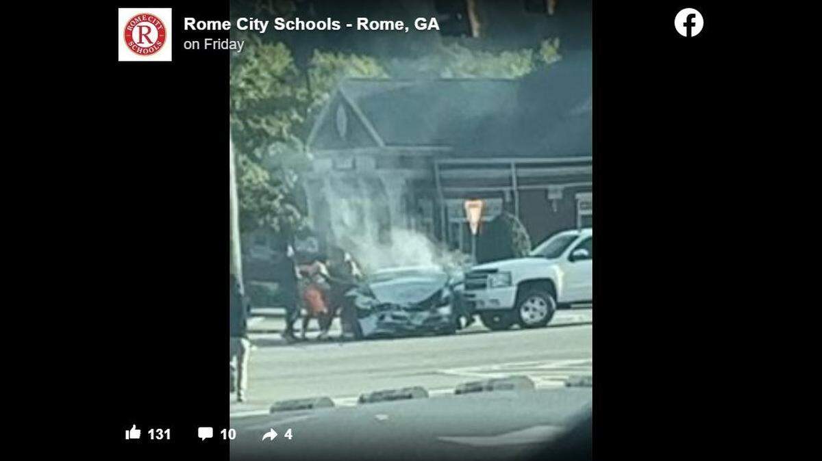 A group of football players helped a woman trapped in a car after a crash outside their high school, a teacher said.