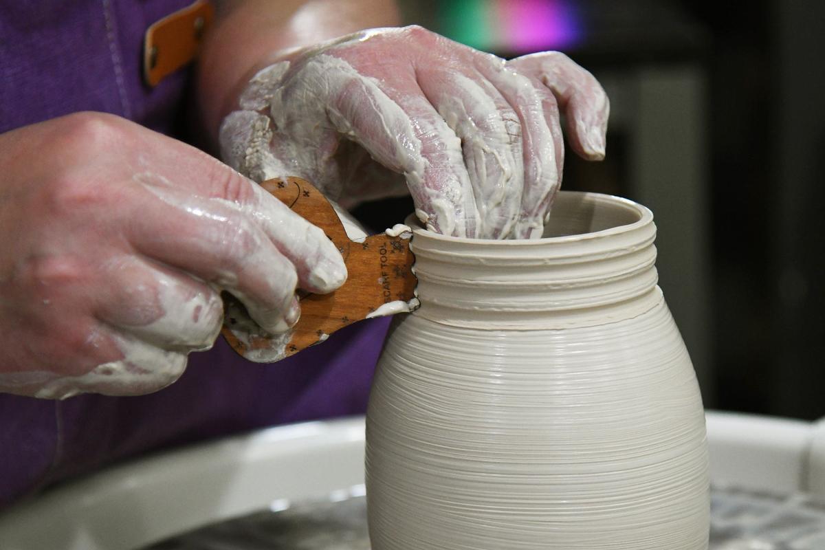 Goodjuju Pottery owner Julie McGlamery adds texture to the edge of a tall container she is working on on a pottery wheel on Tuesday, July 9, 2024, in Forsyth, Georgia. Goodjuju Pottery Studio opened in March and offers pottery making and painting classes in downtown Forsyth.