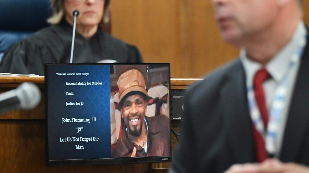 Macon Judicial Circuit chief assistant district attorney Tony May (right) displays a picture of John Fleming III on screens in the courtroom during closing arguments on Thursday, Jan. 22, 2026, at the Bibb County Courthouse in Macon, Georgia. Fleming was confirmed deceased in Macon 2018 after he went missing and investigators found his car with blood splatters and gun shell casings, along with bone fragments nearby.