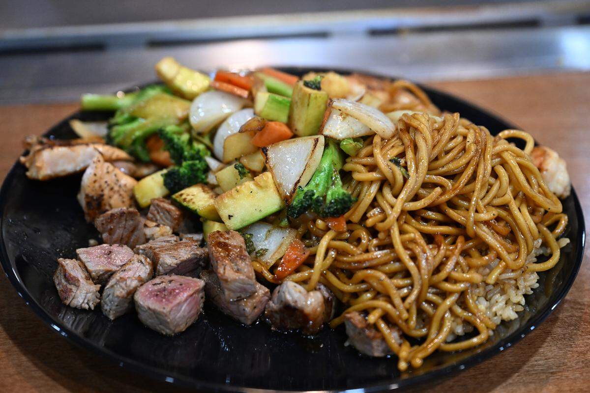 Vegetables, noodles, egg fried rice, filet mignon, salmon, steak, and shrimp that was cooked hibachi style on a grill at a teppanyaki table at the new Koji in Perry.