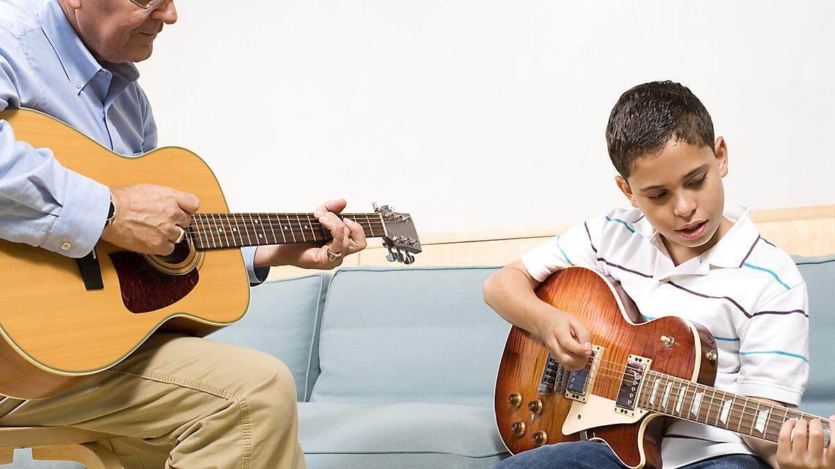 THINKSTOCK PHOTO ILLUSTRATION 
 A teacher and student play guitars.