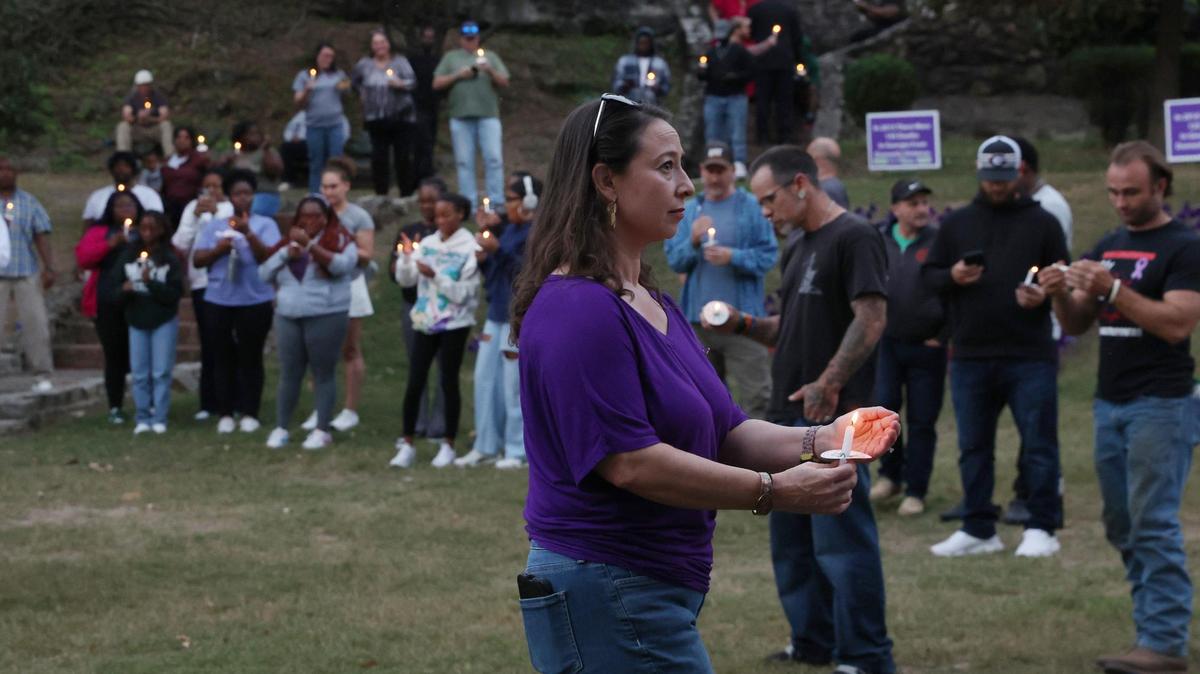 Rescue Mission of Middle Georgia development director Amy Walker walks with a candle through the Domestic Violence Awareness Month candlelight vigil on Tuesday, Oct. 29, 2024, at Washington Square Park in Macon, Georgia. The vigil presented by Rescue Mission of Middle Georgia and Crisis Line and Safe House of Central Georgia honored victims of domestic abuse at the end of October, which is National Domestic Violence Awareness Month.