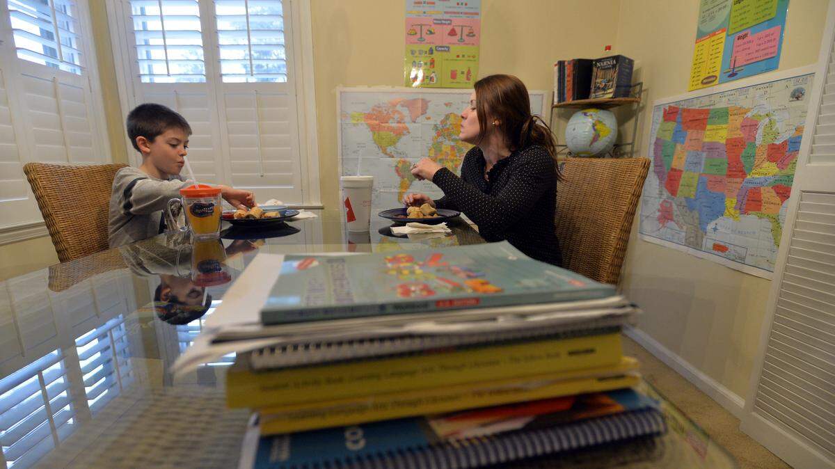 BEAU CABELL/THE TELEGRAPH 
 Shannon Dickerson, right, and her son Levi, 8, have breakfast before cracking the books Thursday. Dickerson, a Georgia Southern grad, home-schools her son at the family's north Macon home, where the dining room doubles as a classroom.