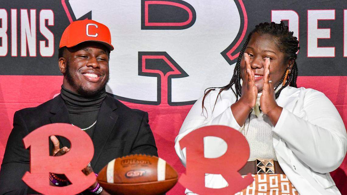 Warner Robins senior defensive end Vic Burley cracks a smile as his mother Heather Burley applauds after signing his National Letter of Intent with Clemson in the school’s auditorium Wednesday morning.
