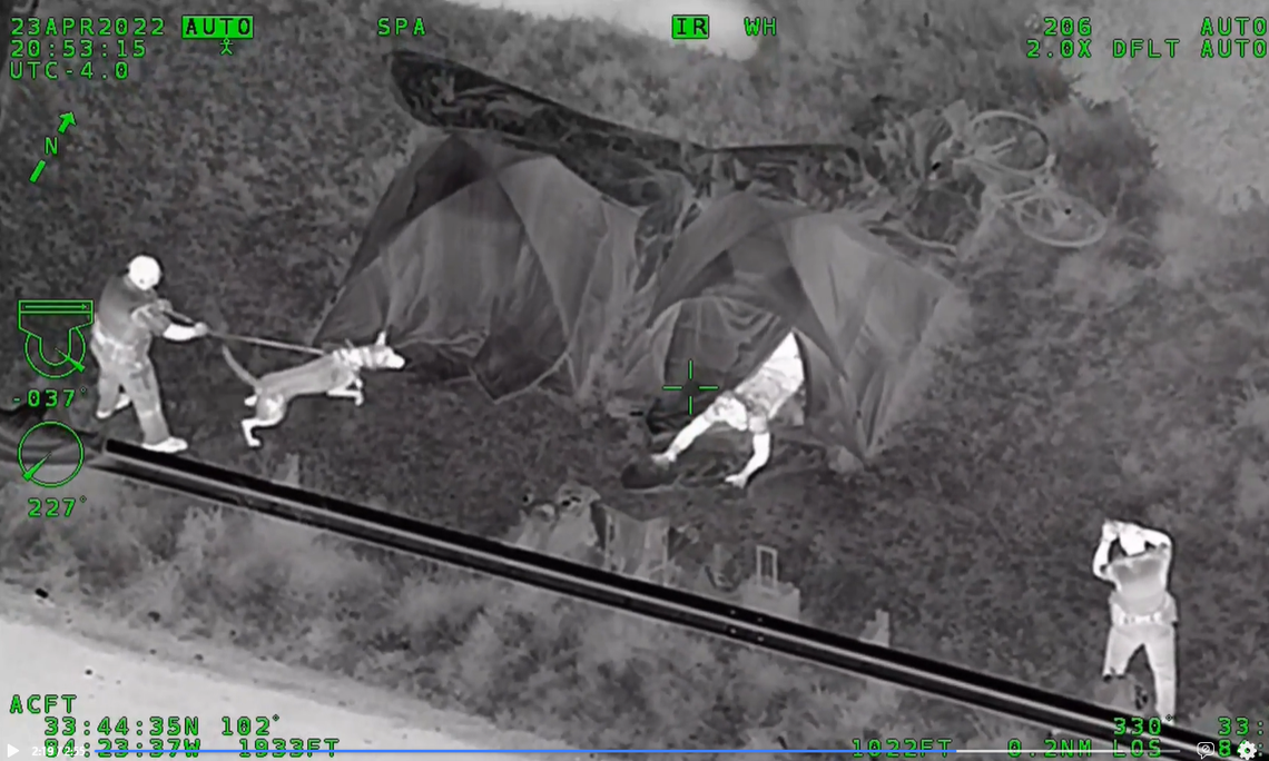 The suspect in the police chase came out of the tent with hands raised and quickly laid on the ground, video shows.