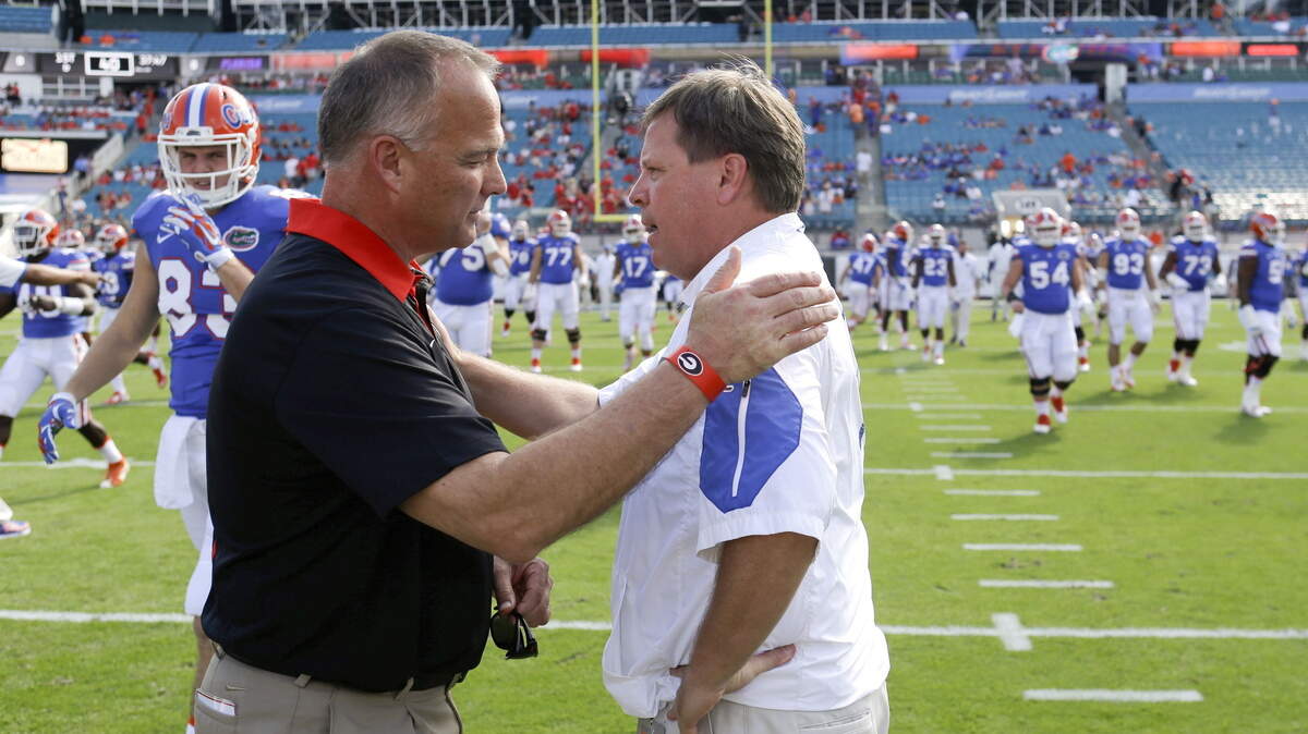 Georgia head coach Mark Richt, left, and Florida head coach Jim McElwain greet each other at midfield field before an NCAA college football game, Saturday, Oct. 31, 2015, in Jacksonville, Fla. (AP Photo/John Raoux)