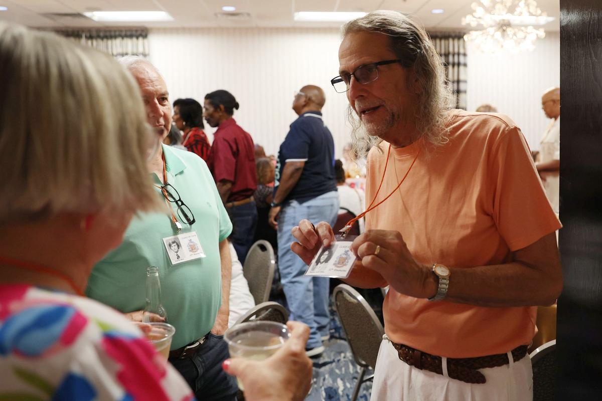 Rodney Keith Miles holds up his name tag while speaking with a reunion attendee during the Central High School class of 1974 50th reunion on Friday, June 21, 2024, at the Wingate by Wyndham Macon in Macon, Georgia. The class of 1974 was the first graduating class to attend all four years at Central High School, which was established in response to the integration of Bibb County Schools in 1970 by combining A.L. Miller and Lanier High School.