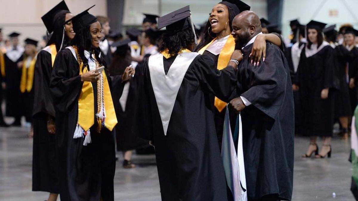 Destiny Pallord, at right, gives her basketball coach Daniell Johnson a big hug as Houston County High School graduates assembled for commencement exercises in May 2018. In 2019, Houston County schools recorded higher SATs than the national average.