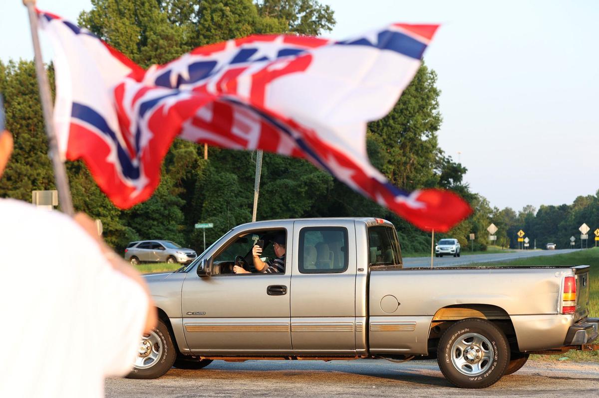 A man records the group of Trump supporters out of his truck on the side of Eisenhower Parkway on Monday, July 15, 2024, in Lizella, Georgia. A half dozen supporters, including members of the Bibb County Republican Party, gathered to show their support for former president Trump two days after an attempted assassination attempt on him in Pennsylvania.