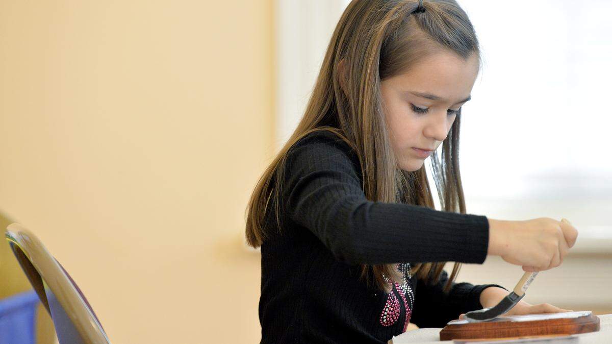 JASON VORHEES/THE TELEGRAPH Macon, GA, 12/06/2015: 
 Alexa Economopoulos, 6, brushes crafting glue on a plaque while making a St. Nicholas icon at Holy Cross Greek Orthodox Church December 6.