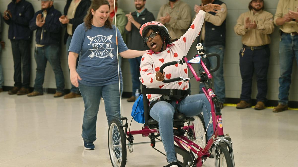 Karrington Starks, 17, rides her new adaptive bicycle around the auditorium of Georgia Power Company on Tuesday, Nov. 19, 2024, in Macon, Georgia. The bicycle was custom designed by Freedom Concepts and gifted to Starks by Georgia Power.