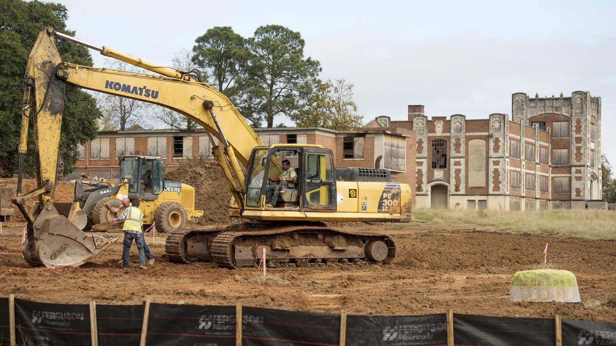 Crews from Appling Brothers Co., a subcontractor on the project, remove old concrete while grading an area near the old A.L. Miller High School on Thursday.