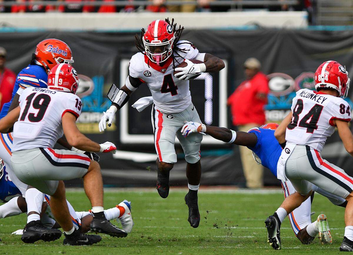 DONN RODENROTH,Jacksonville, Florida, 10/30/2021: Georgia Bulldog James Cook break through the Gator defense for a Georgia 1st down in action Saturday in Jacksonville.