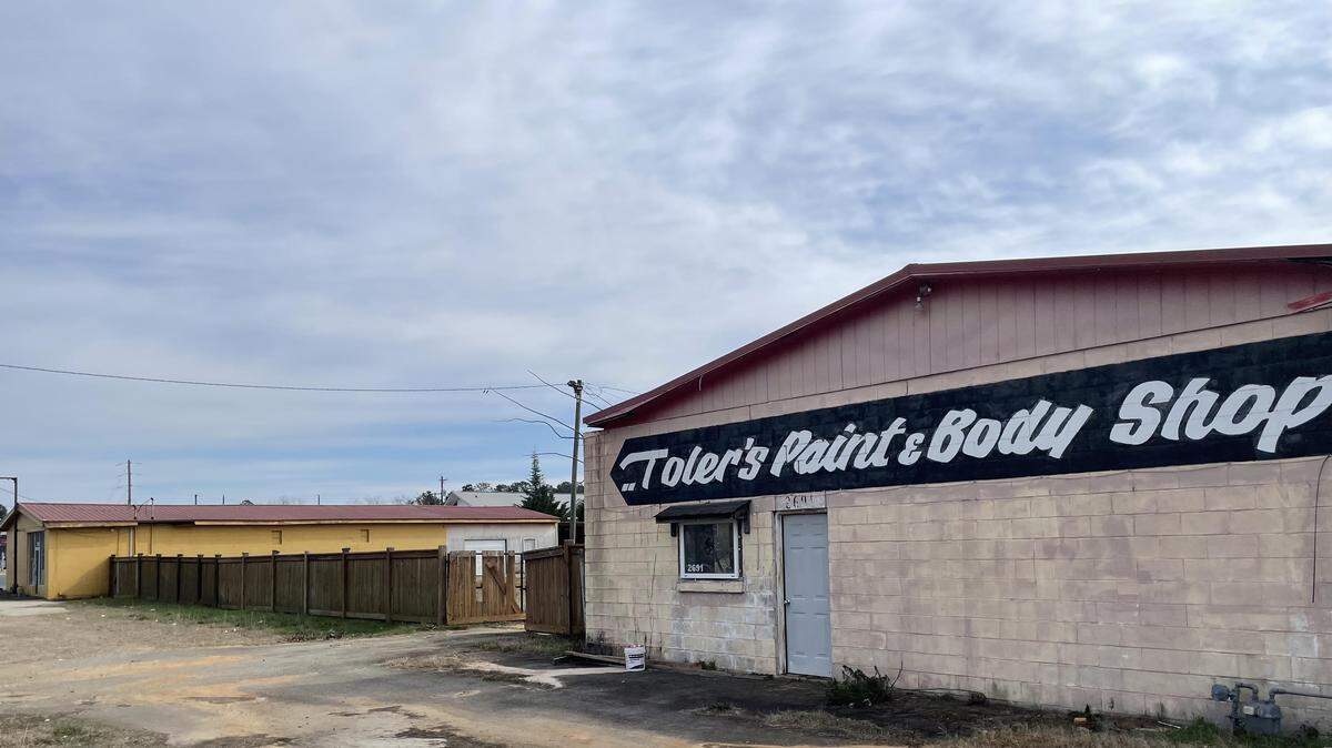 The former body shop, fence and neighboring former retail store off Watson Boulevard will all come down in order to pave the way for Small Sliders and Guthrie’s restaurants.