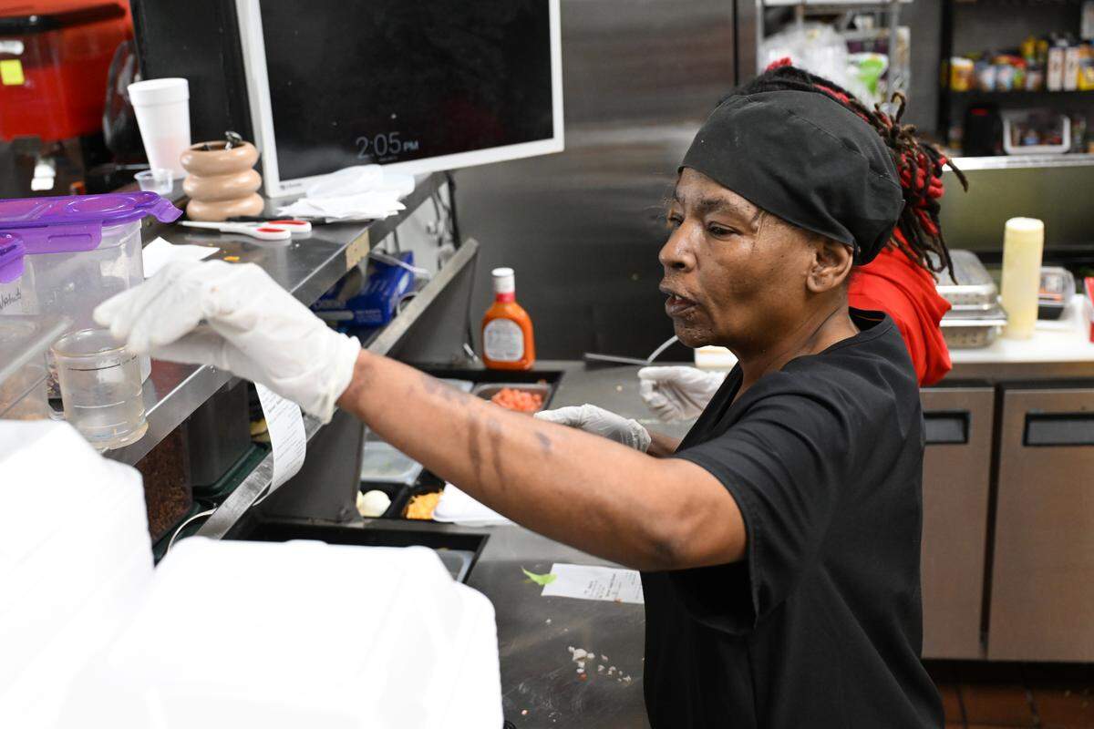 “The Salad Queen” and The Salad Palace owner Tasha Williams works on an order in the kitchen of The Salad Palace at its new location at 701 Eisenhower Parkway, Suite A. Williams first opened her restaurant, then called Salads to Go, in east Macon in 2014.
