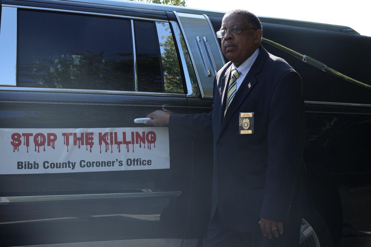 Bibb County Coroner Leon Jones stands in front of one of his “Stop The Killing” hearses on Friday, Aug. 30, 2024, outside of Richard Robinson Funeral Home in Macon, Georgia. Jones has investigated deaths at the coroner’s office since 1990 and said that many start with verbal disputes.