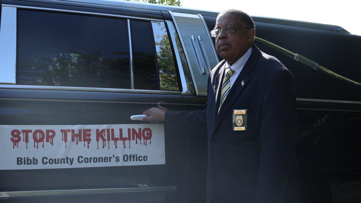 Bibb County Coroner Leon Jones stands in front of one of his “Stop The Killing” hearses on Friday, Aug. 30, 2024, outside of Richard Robinson Funeral Home in Macon, Georgia. Jones has investigated deaths at the coroner’s office since 1990 and said that many start with verbal disputes.