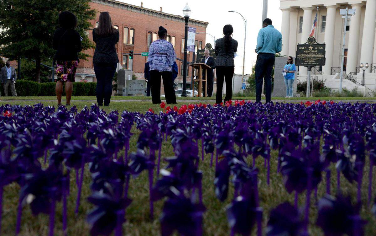 Macon Mayor Lester Miller speaks Tuesday at a candlelight vigil for Domestic Violence Awareness Month in Rosa Parks Square. The purple windmills represent the people who have lost their lives to domestic violence in Georgia, and the red windmills represent victims from Middle Georgia.