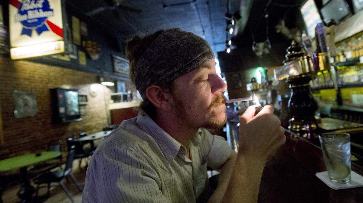 Cody Jones, 27, of Macon lights a cigarette at The Hummingbird Stage & Taproom Thursday afternoon. Jones, who has been smoking since was 14 and works downtown, said he was not surprised that Macon-Bibb's smoking rate is higher than the national average.