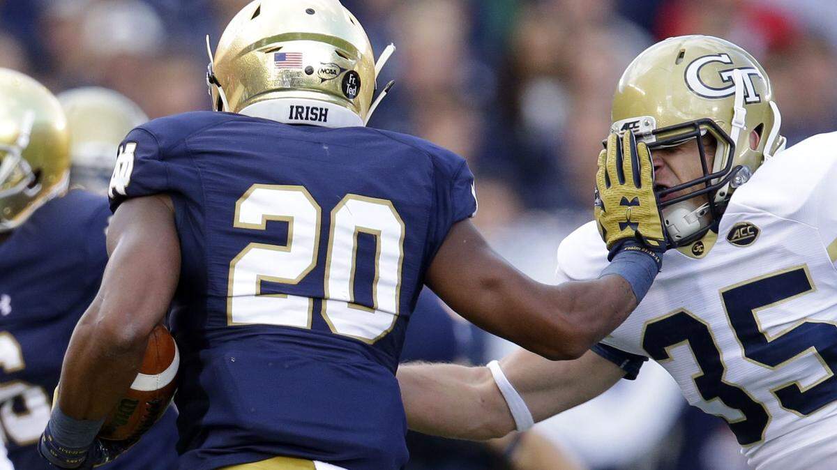 Notre Dame running back C.J. Prosise (20) pushes off the tackle of Georgia Tech linebacker Tyler Marcordes (35) during the first half of last Saturday’s game.