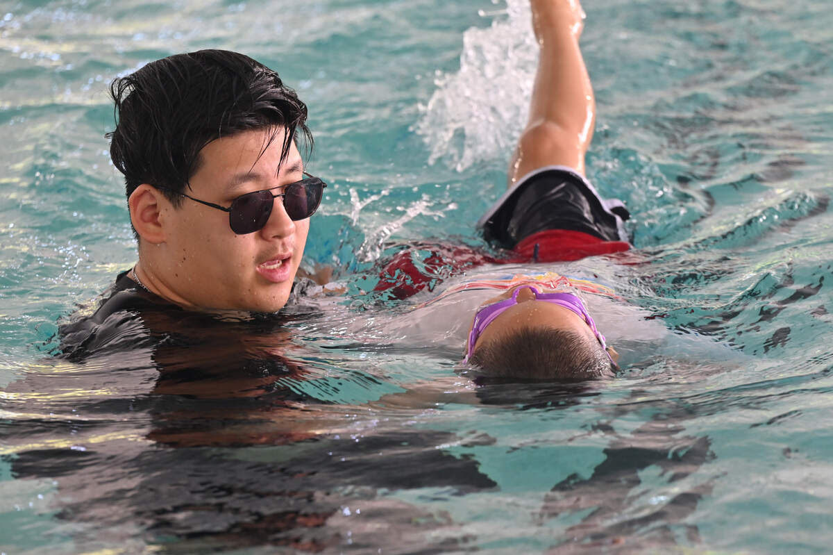 Fusion Swim Team instructor Reece Hatfield leads a student through the pool at swim lessons on Tuesday, July 7, 2026, at the Northside Pool in Macon, Ga. Fusion Swim Team began its Swim America curriculum swim lessons last summer for swimmers 15 and under.