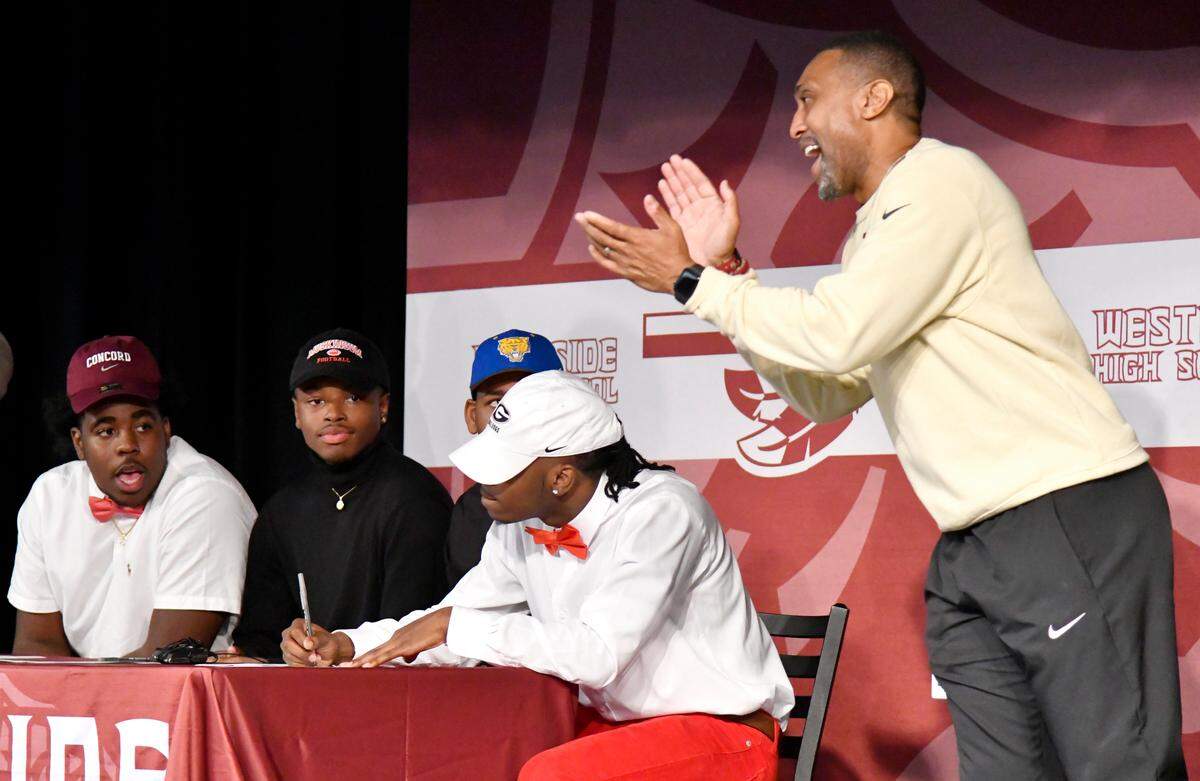JASON VORHEES/THE TELEGRAPH Macon, GA, 02/05/2020: Westside football head coach Sheddrick Risper claps his hands as Jehlen Cannady signs with the University of Georgia during a ceremony in the school’s cafeteria Wednesday. Other signees, from left, JaDarius Mann signed with Concord University, Antonio Scott signed with Muskingum University and Chad Sanford signed with Fort Valley State.