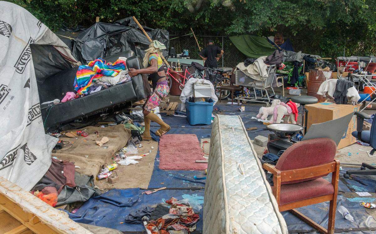 A resident of the Macon homeless encampment between downtown and Interstate 16 struggles to move a couch from their tent before a bulldozer rolls to take it away. Macon-Bibb County bulldozed one of the city’s largest homeless encampments.