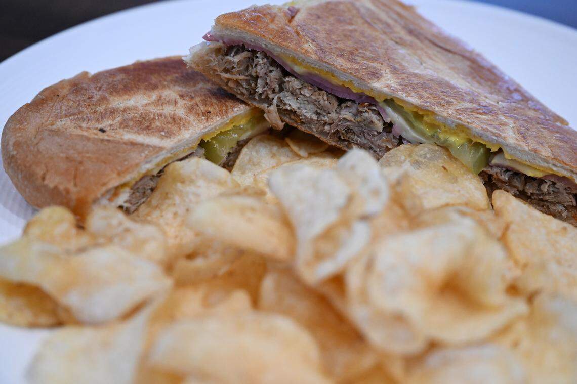 The Cubano sandwich from J. Reid’s Tavern features roasted pork, ham, provolone, pickles, mustard on cuban bread served with a side of kettle chips. 