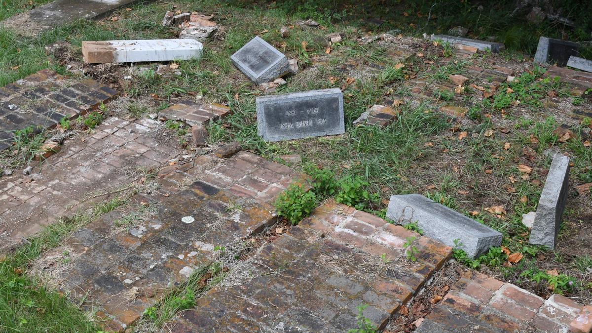 Headstones from the Woolfolk family sit overturned in the Rose Hill Cemetery on Wednesday, July 17, 2024, in Macon, Georgia. The Woolfolk family marker includes nine family members who were murdered in 1887. The area was vandalized this month.