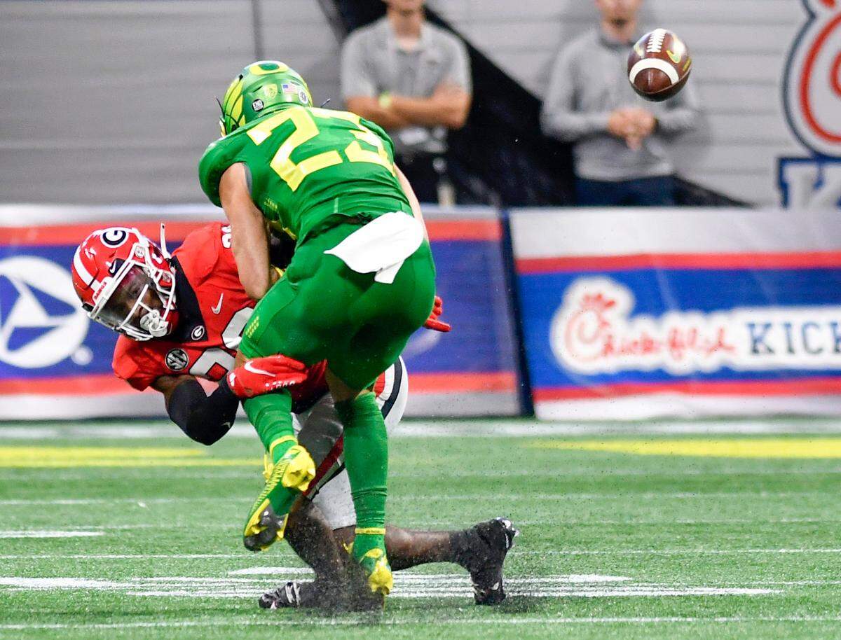 Georgia defensive back Christopher Smith (29) knocks the ball loose from Oregon receiver Chase Cota (23) during the Bulldogs’ win Saturday in Atlanta.