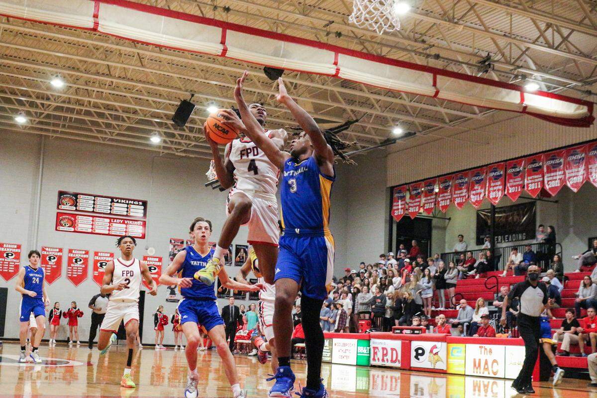 FPD’s Jay King (left) attempts a layup over Tattnall’s Antone Johnson during their region playoff game on February 17, 2022.