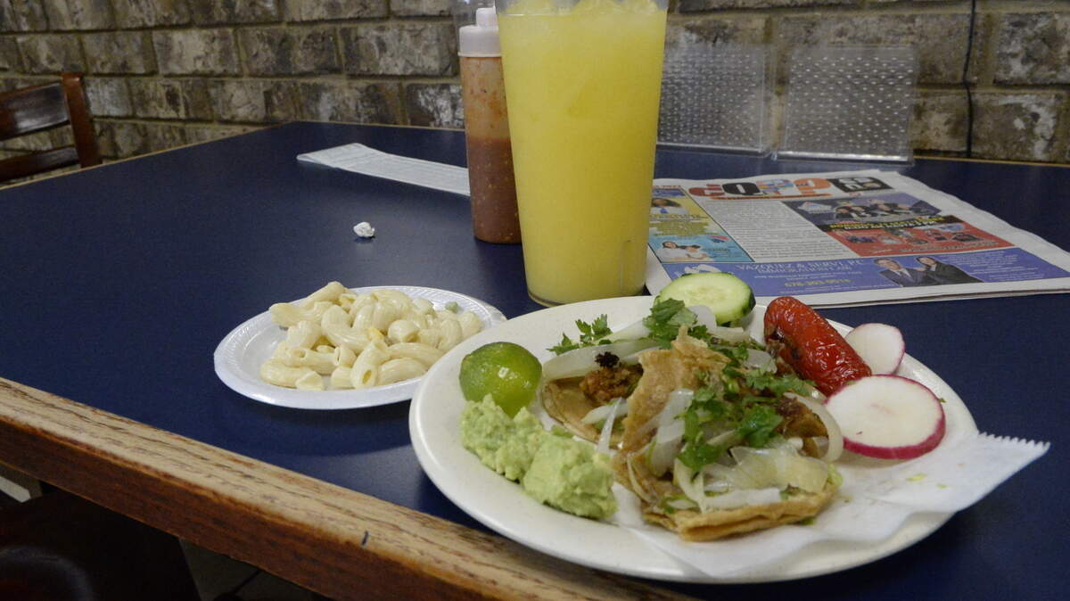 A plate of tacos paired with a side and fresh mango juice from La Mexicana, a taqueria on Houston Road owned by Maribel Medina.